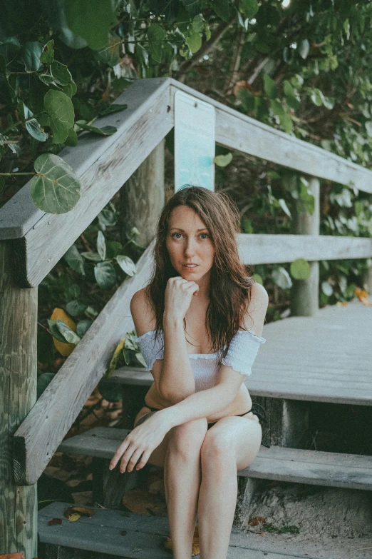 a woman is sitting at the bottom of a set of stairs