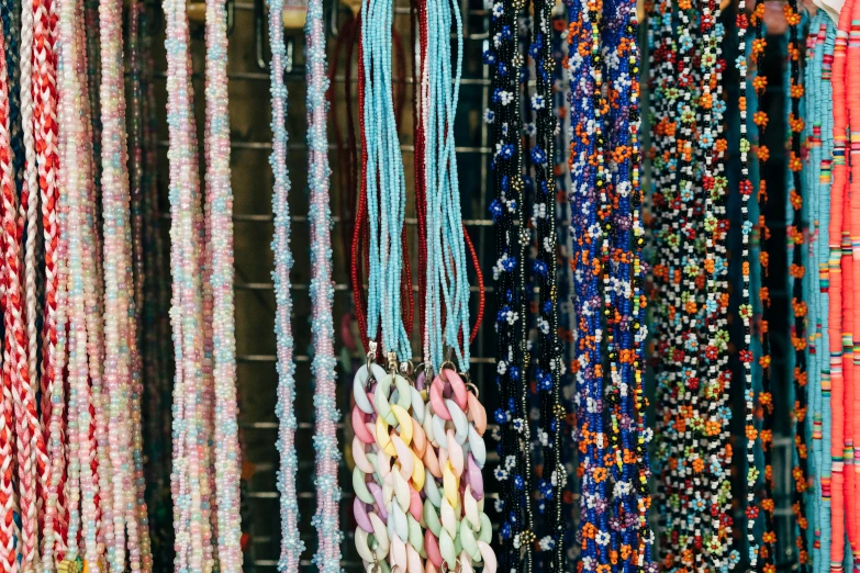 many pieces of fabric and some beads are hanging together