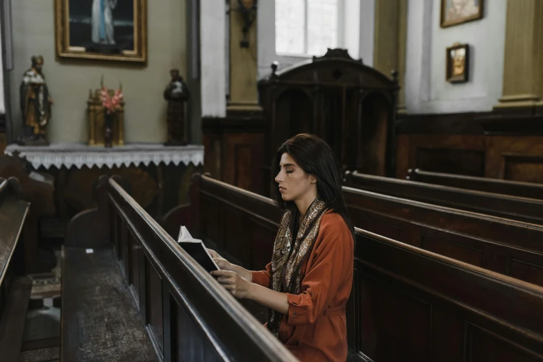 a woman standing in a church holding soing up