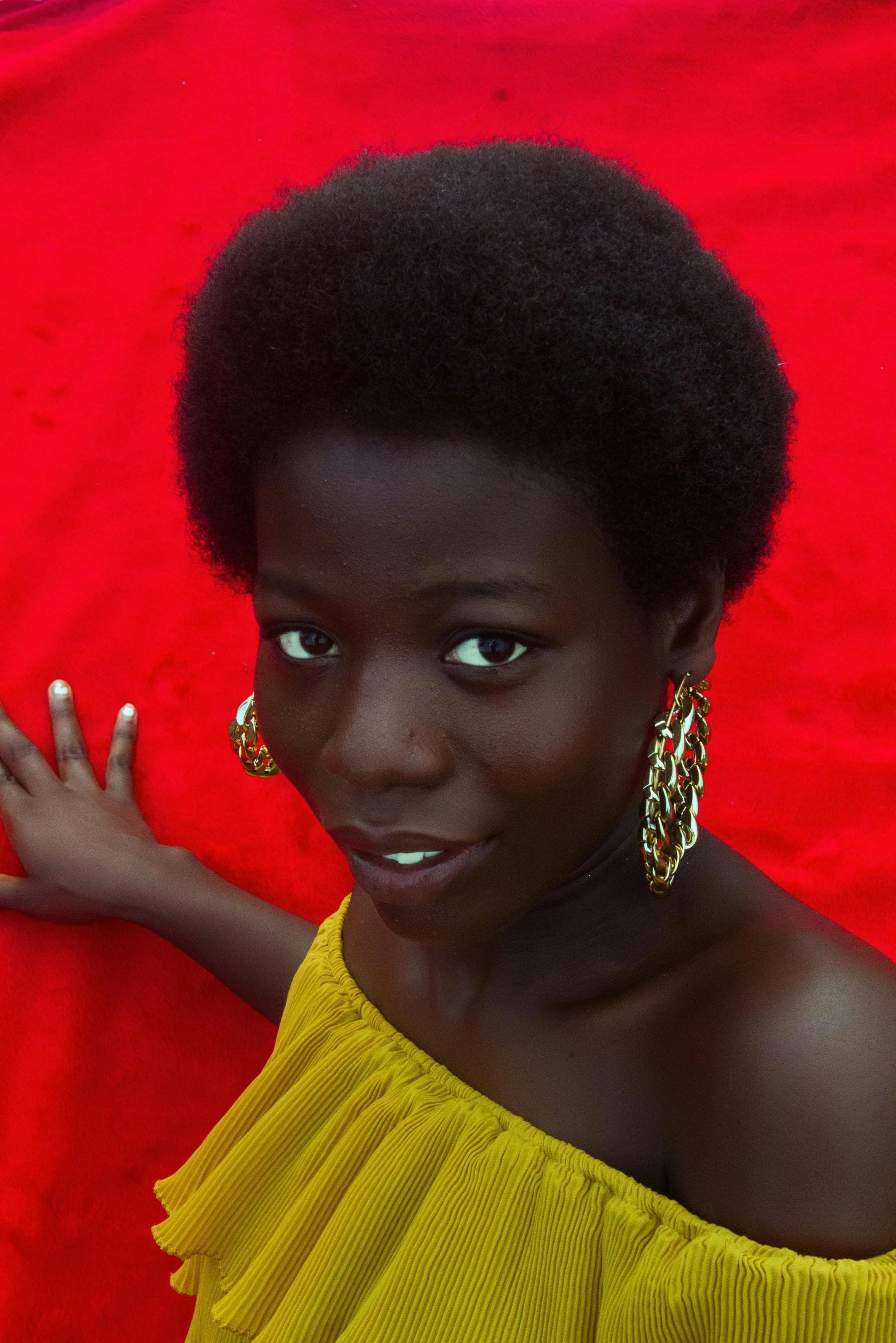 a person in a yellow top standing on a red cloth