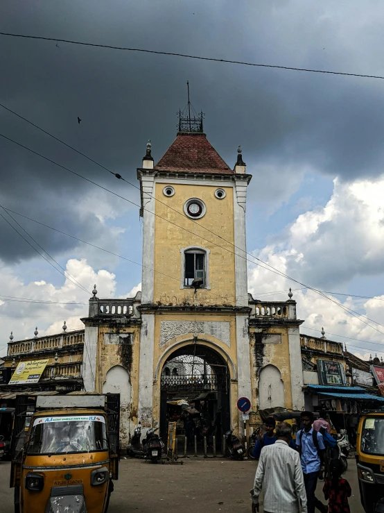 an old building with a clock tower near cars