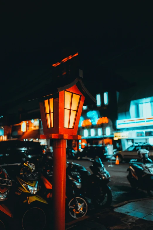 a lamp post with cars parked on the road