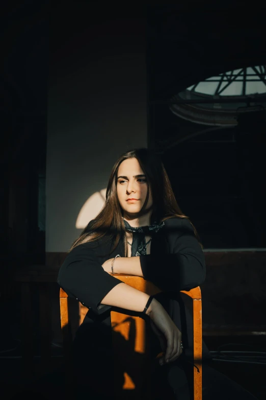 a girl sitting on a chair with her arms crossed