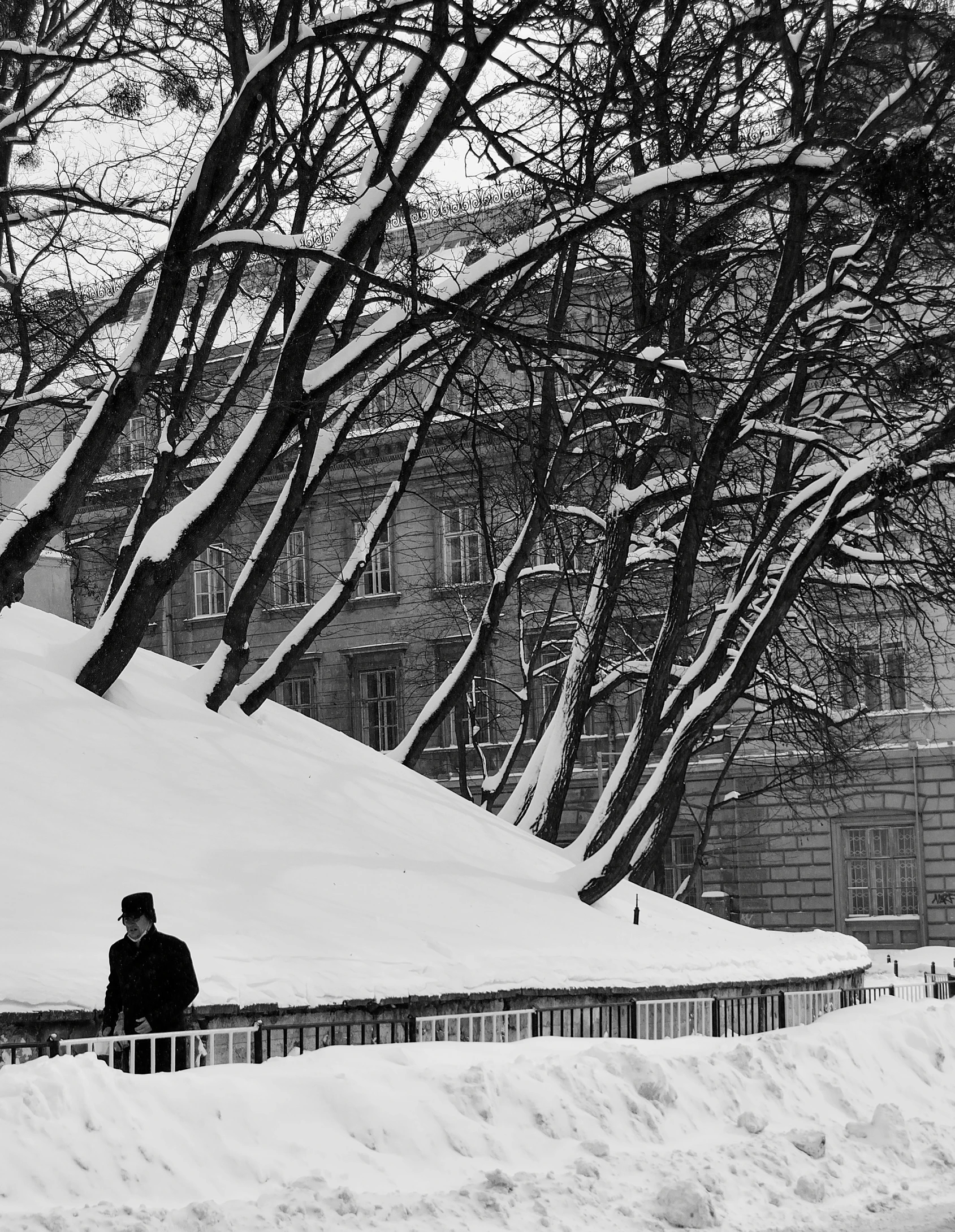 a person is sitting in the snow on a bridge