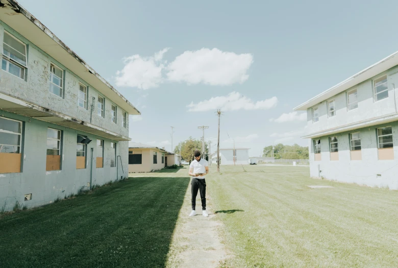 a person standing in the grass outside a white building