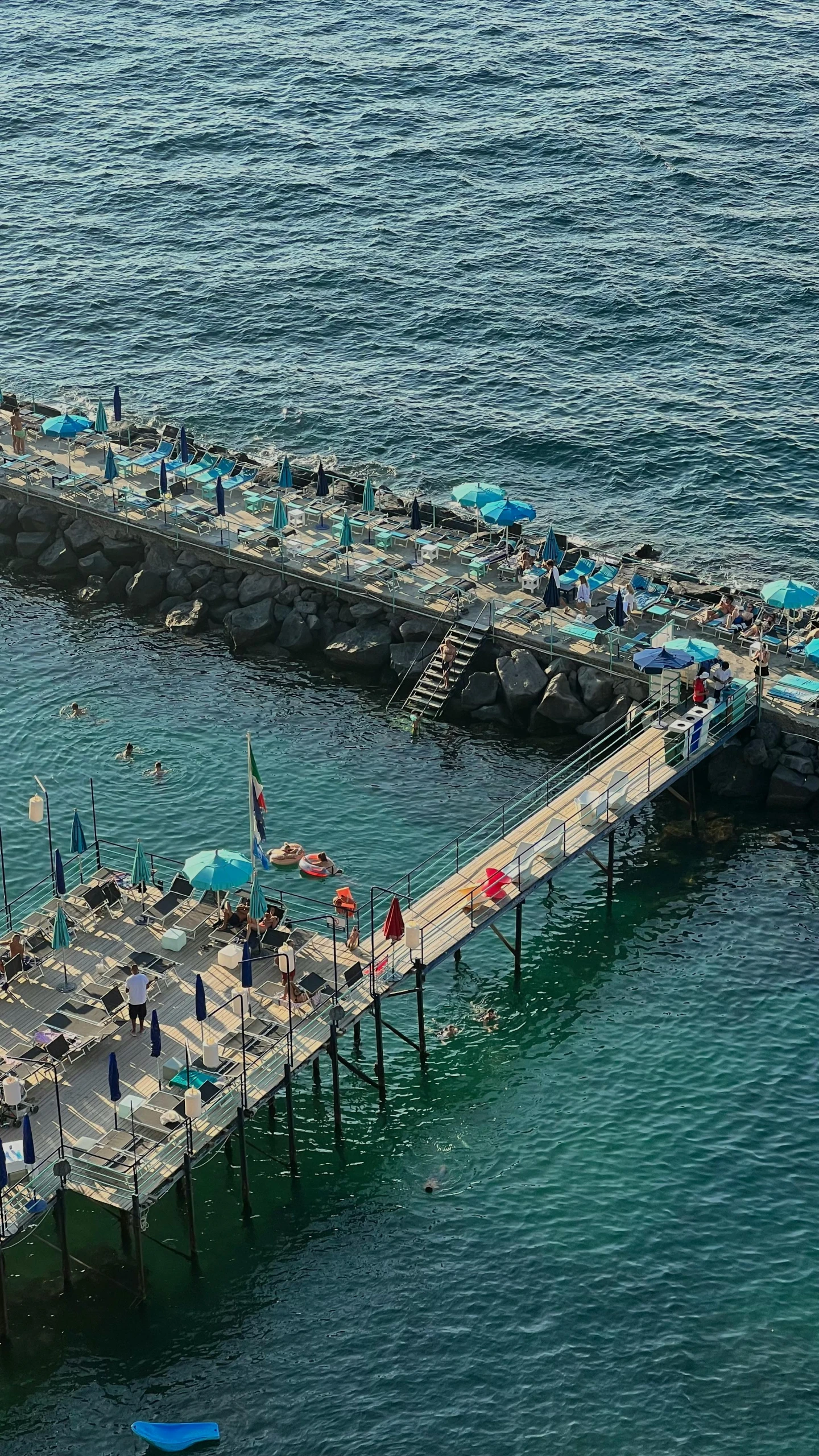 a pier that has umbrellas and tables next to it