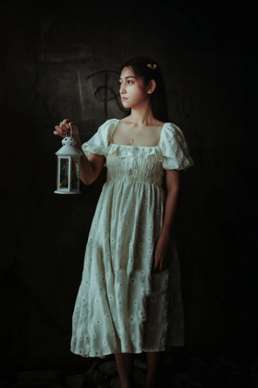 a woman is holding a lantern in a dark room