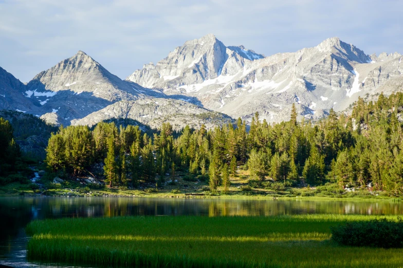 an image of mountains and forests on a lake