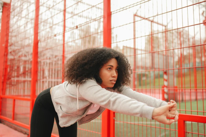 a woman is holding her fist out in an orange cage