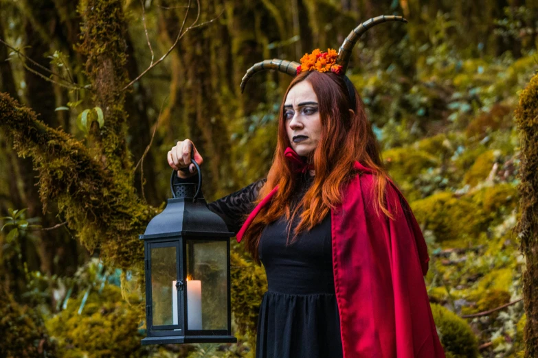 a woman dressed in costume holding up a lantern with horns