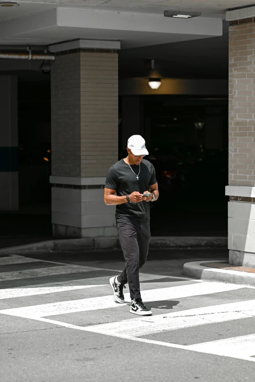 a young man walking through an urban crosswalk