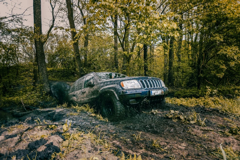 an suv making a face while being driven through mud