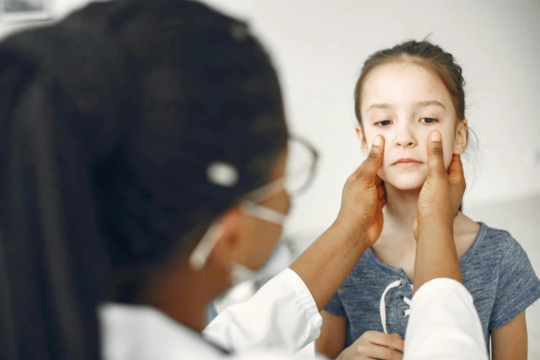 a woman helping a little girl in her eyeglasses