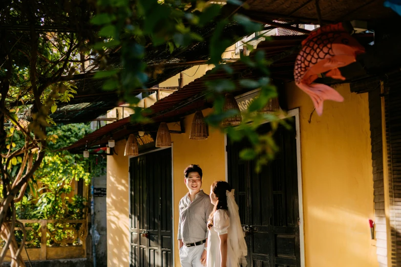 a bride and groom standing outside of their home