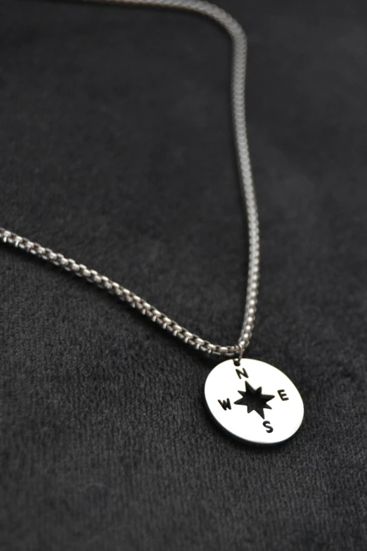 a silver chain and a star is on a necklace