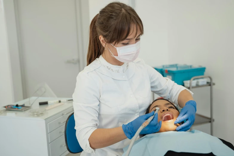 the woman is getting the dental treatment at the clinic