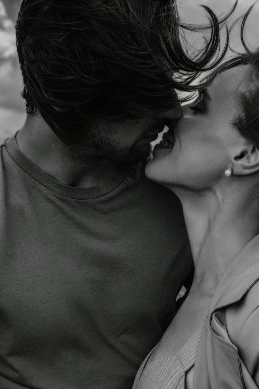 two women sharing a kiss as they walk on the beach