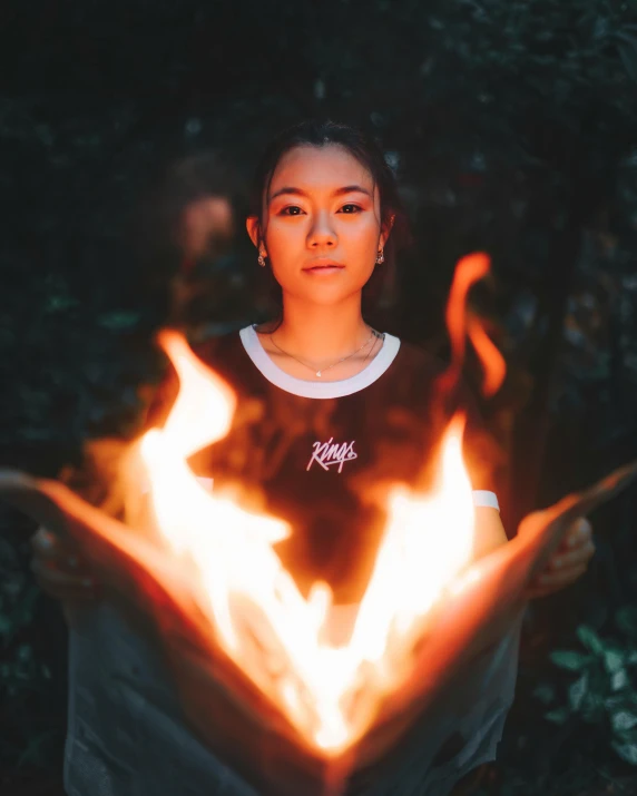 a woman in a black shirt holding a flame