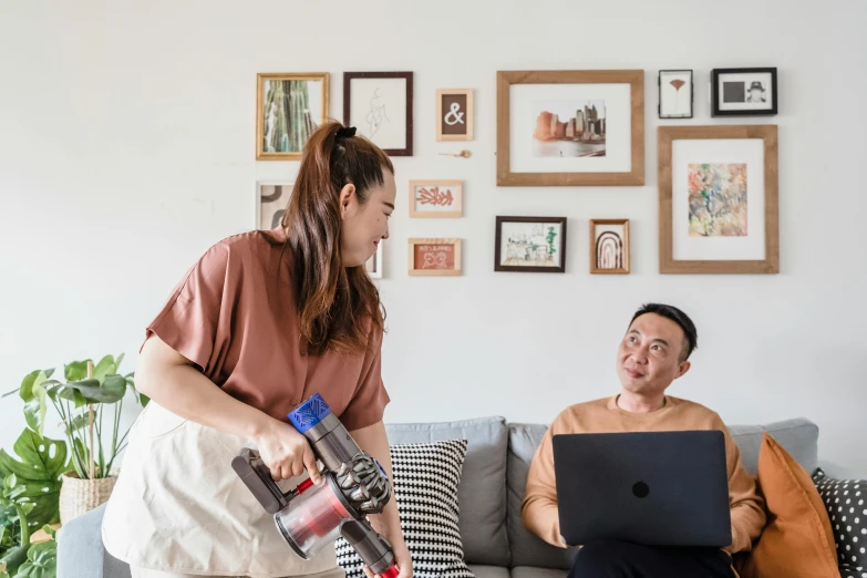 a man and a woman looking at the screen of a laptop