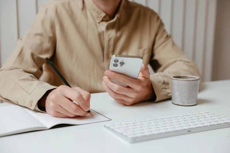 a man using his phone while sitting at a table