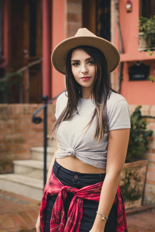 the  wearing a hat and top poses on the street