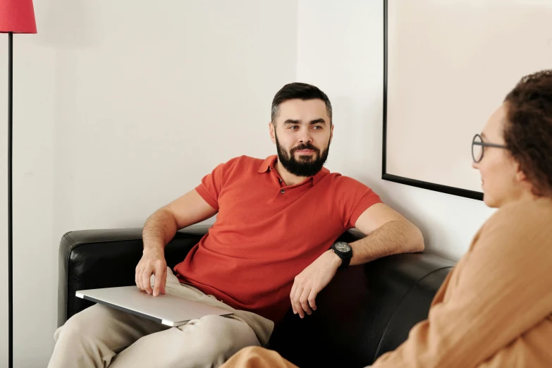 a bearded man talking to an older woman