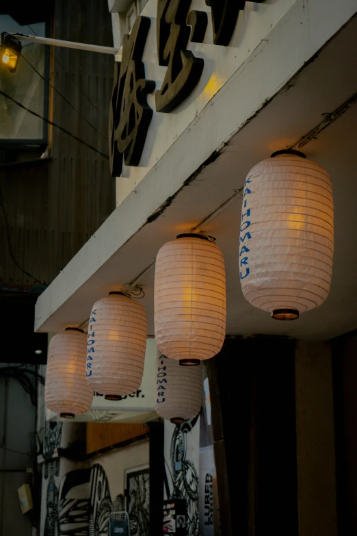 three lamps hung from the ceiling near some signage