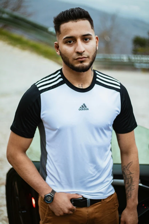 a man standing next to a green car