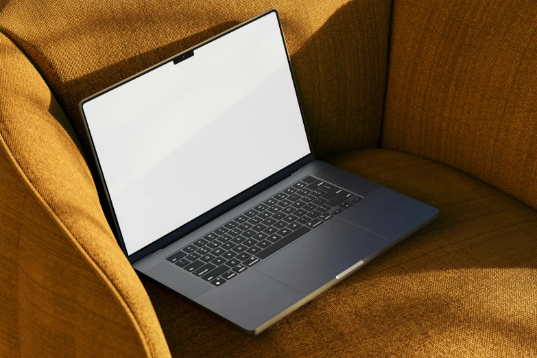 a silver laptop that is sitting on a yellow chair