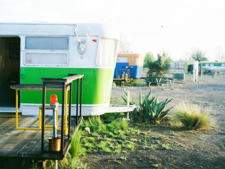 a trailer parked on a dirt lot next to a green building