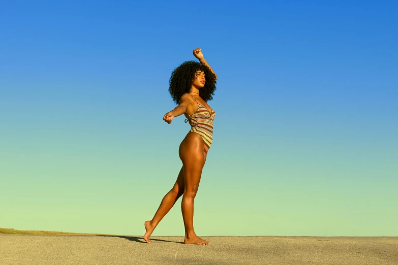 a woman in a bikini and sandals is walking