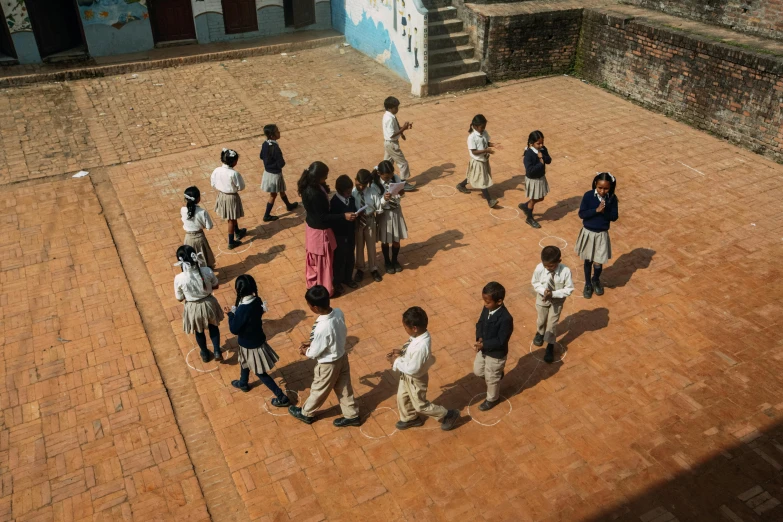 children standing in a circle on a brick road