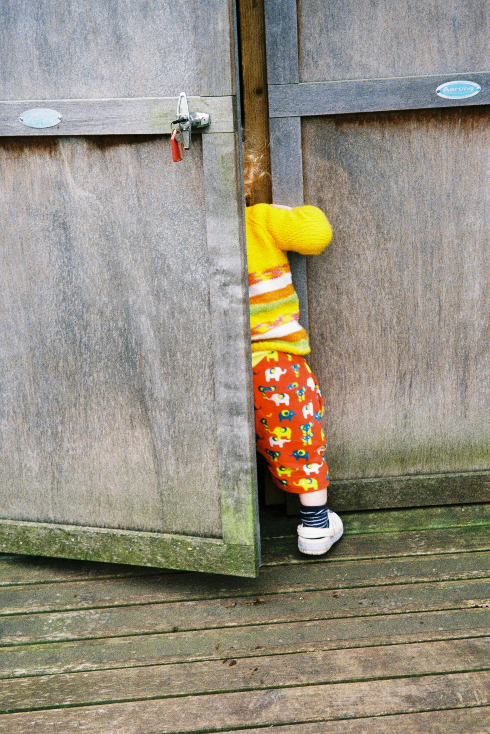 child standing in front of open wooden doors