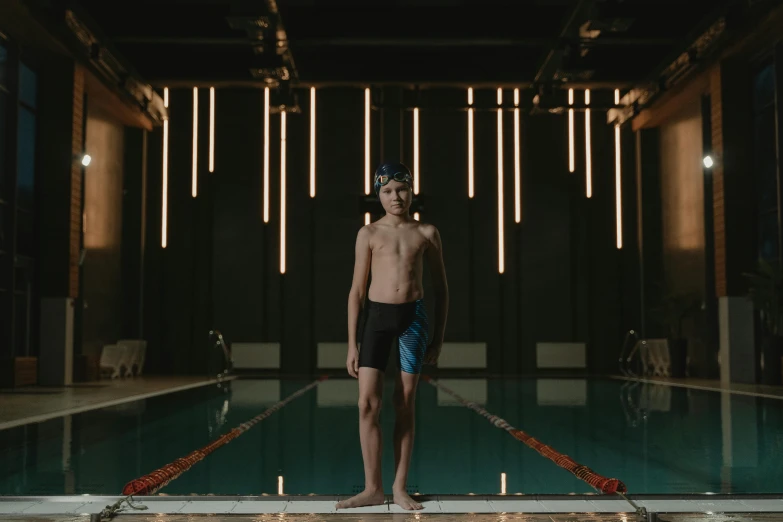 a man standing by an indoor swimming pool