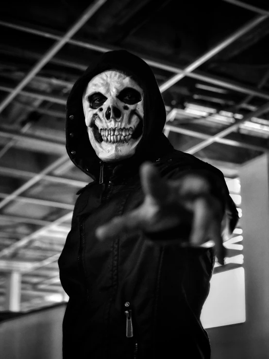 a man wearing an evil mask pointing at the camera