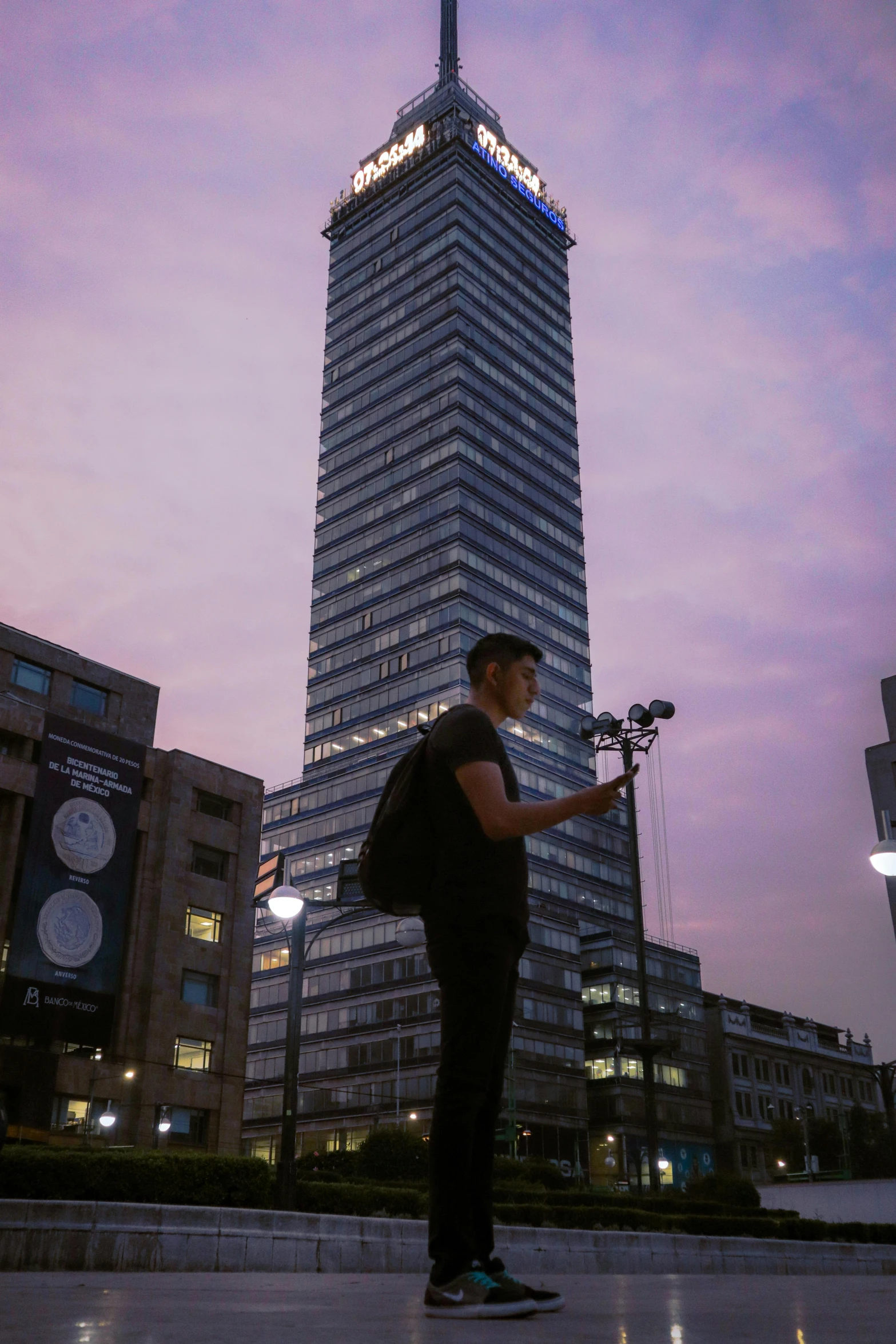 man holding bicycle in city with very tall building in background