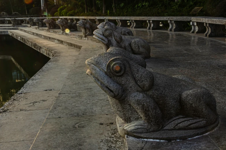 statues of elephants resting on cement ledges at night