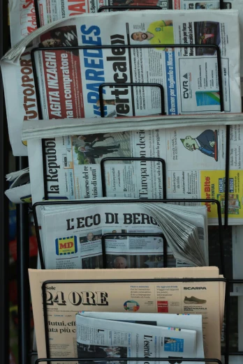 a black newspaper stand with newspapers sitting on it