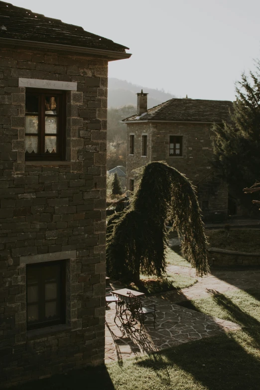 a bench sits on the grass in front of a stone building