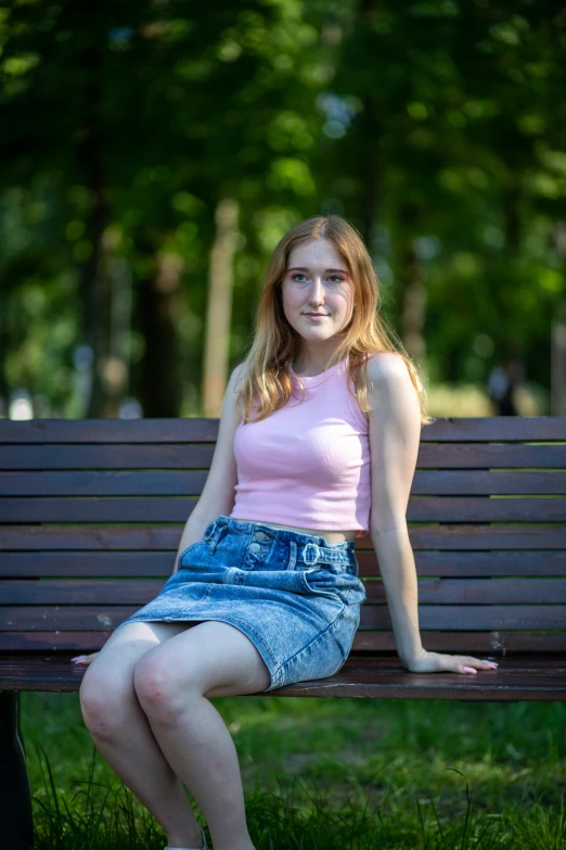 a woman sitting on top of a wooden bench