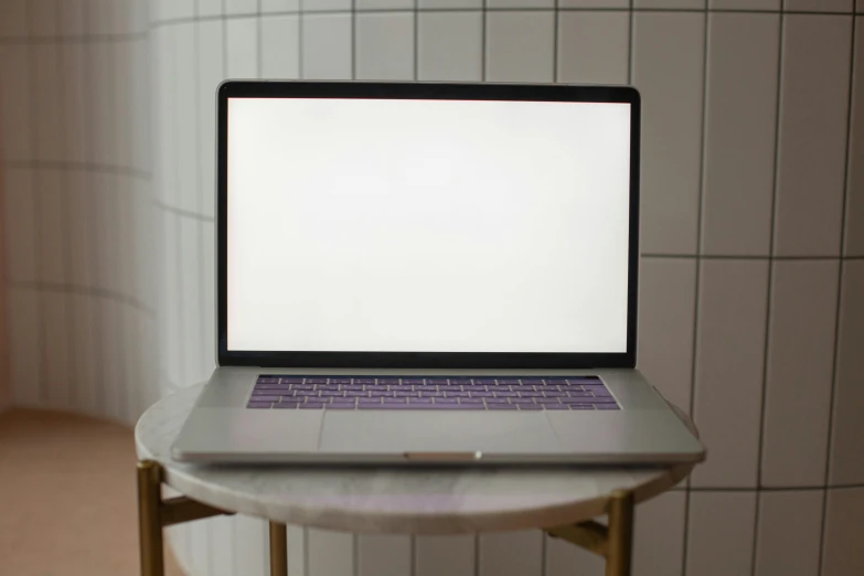 a laptop on a white table in a bathroom