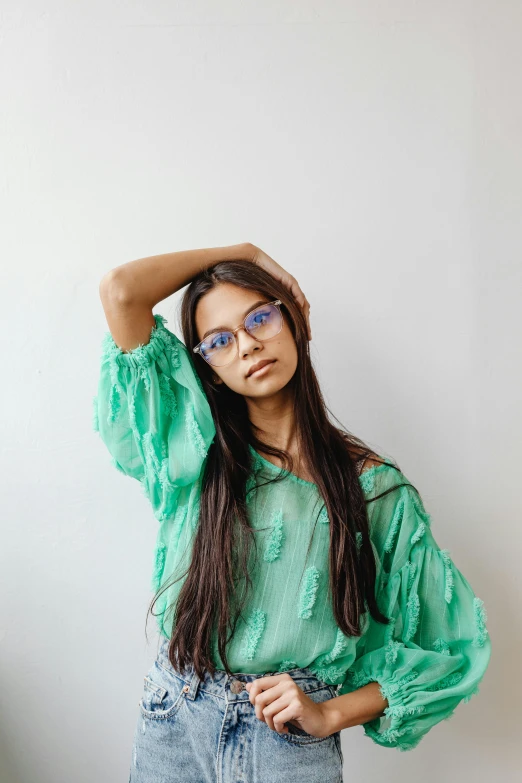 a girl with her hands to her forehead wearing sunglasses