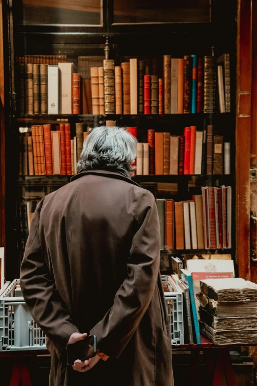 a man that is standing near a book shelf