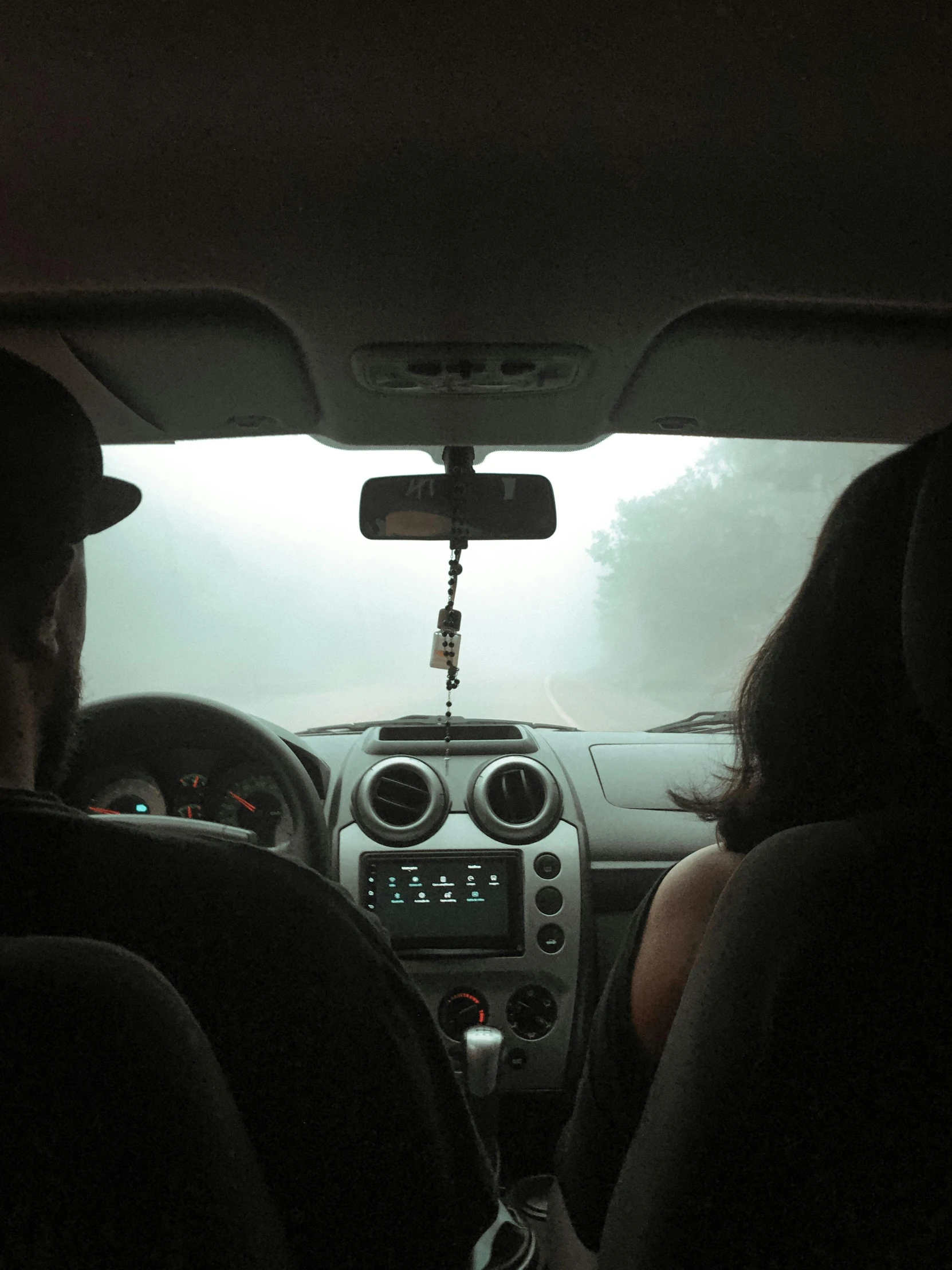 two people sitting inside of the back seat of a car