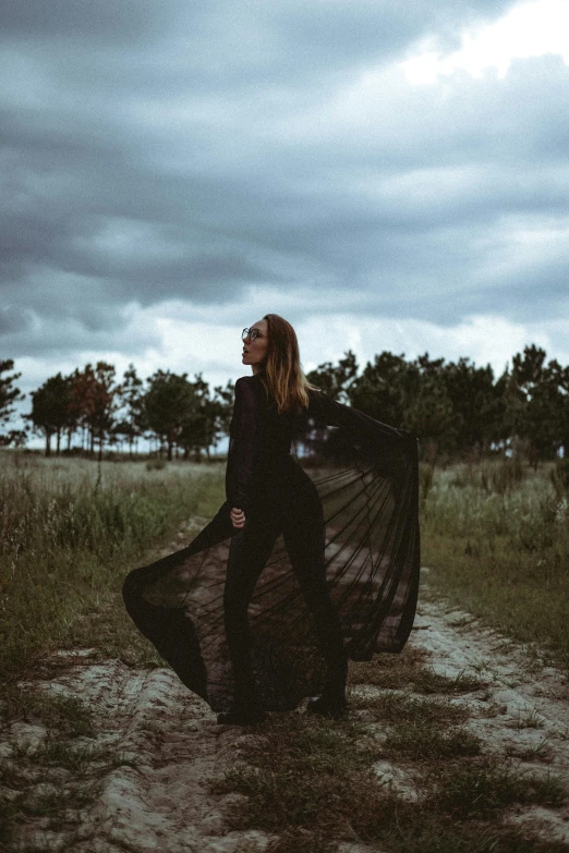 a young woman is holding an umbrella on the field