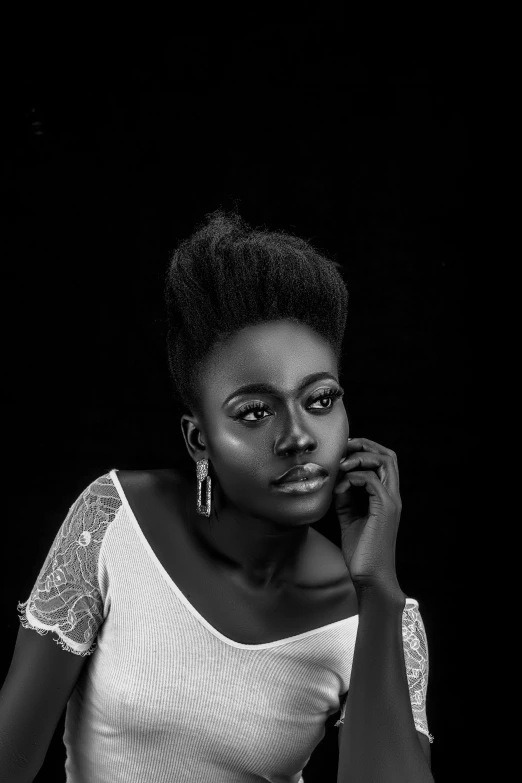 a woman wearing a shirt sitting down in front of a black background