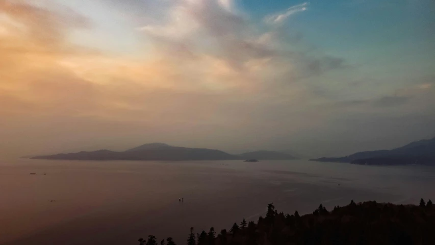 a mountain view shows clouds in the sky and trees