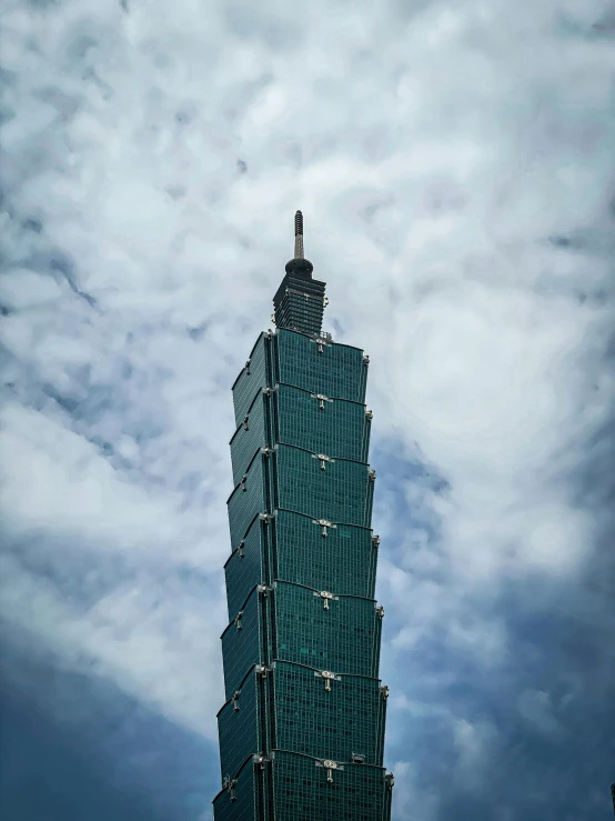 a very tall green building with a clock on it