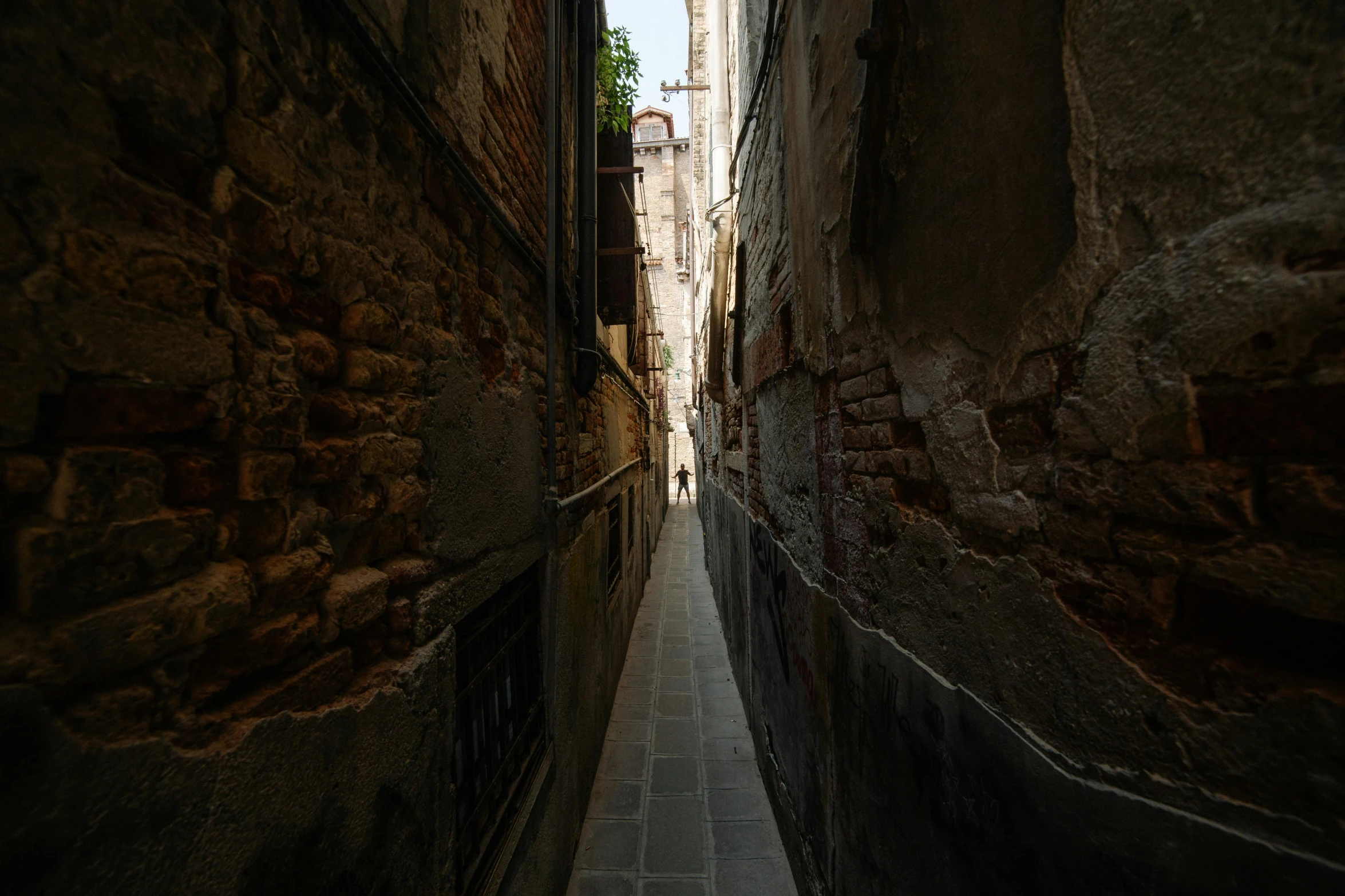 a narrow alley with two steps down to one