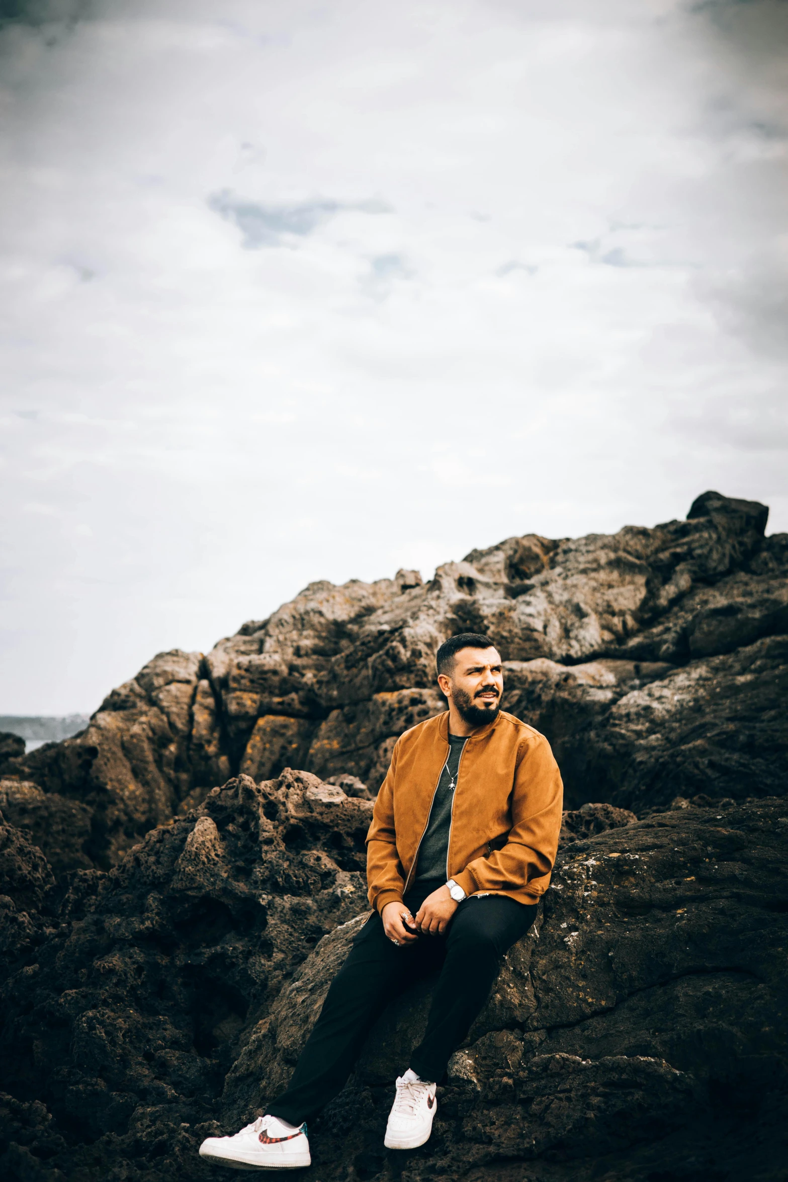 a man that is sitting on some rocks